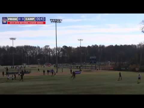 A soccer match is underway on a grass field with trees in the background. The scoreboard displays a 0-0 score at 6:43.