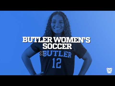 A person wearing a Butler women's soccer jersey with the number 12 stands against a blue background, smiling, with hands on hips. The text "Butler Women's Soccer" is prominently displayed.