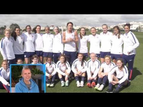 A women's soccer team poses together on a field in white jerseys. A small inset image shows a woman in a blue hoodie.