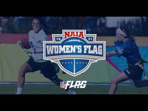 Two women playing flag football, one in a white jersey running with the ball and the other in a blue jersey attempting to grab her flag. NAIA Women's Flag and NFL Flag logos are visible.