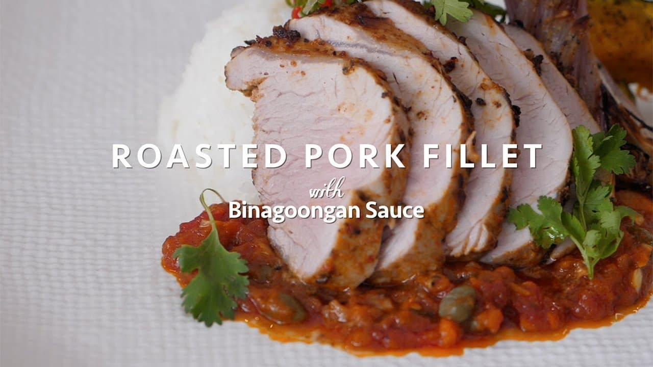 Sliced roasted pork fillet with Binagoongan sauce, garnished with cilantro, served on a white plate.