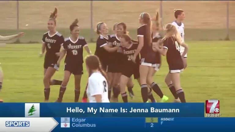 Jenna Baumann - Wisconsin NIL Amount, Net Worth, Player Information, Stats 5 A group of female soccer players in black Everest jerseys celebrate on a grassy field; TV graphics identify Jenna Baumann and display sports scores.